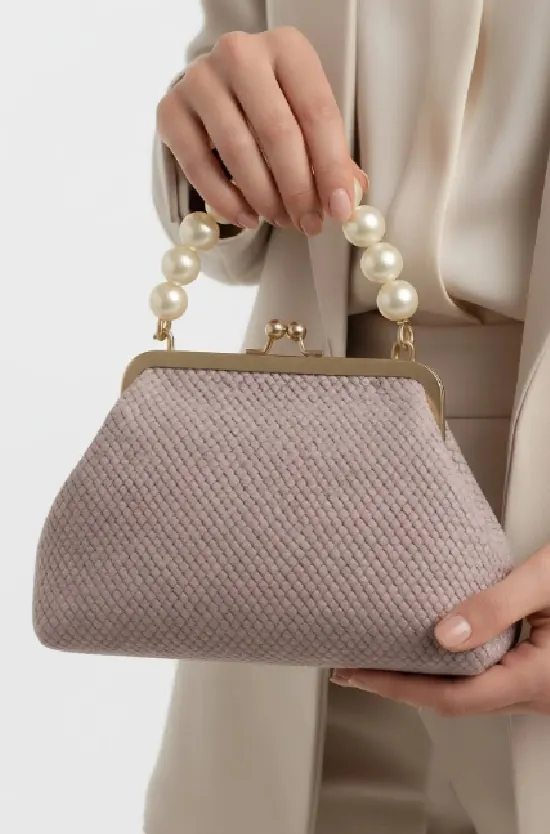 İnci saplı, dokulu bir clutch; modelin elinde